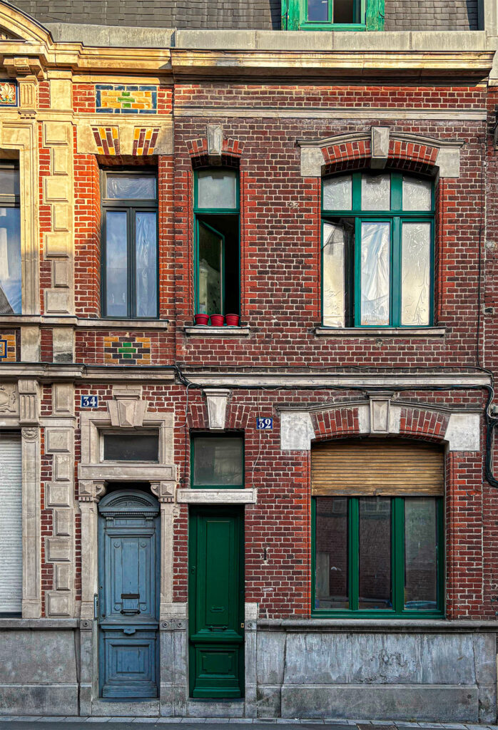 Façades en briques colorées de deux maisons côte à côte dans le quartier du Trichon