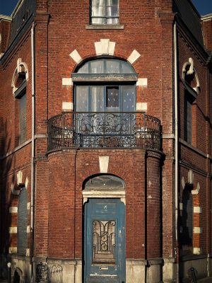Red brick house with blue woodwork. Architecture from the 1930s, or perhaps even earlier.